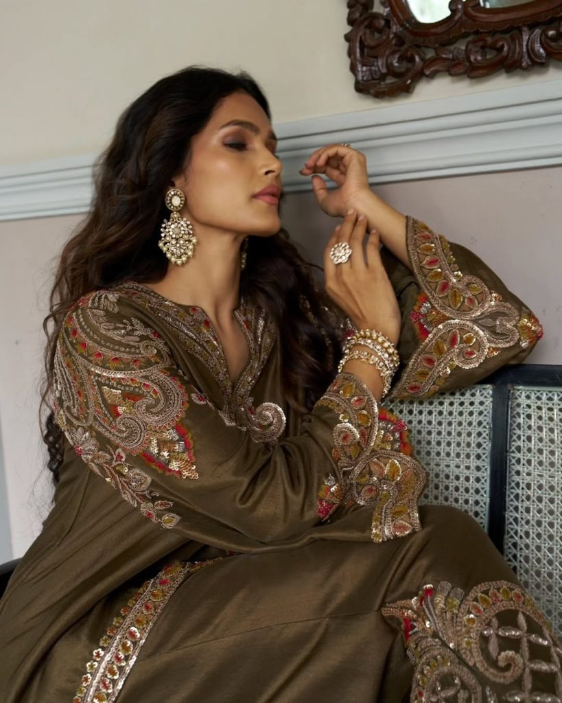 Bride in olive embroidered outfit wearing polki chandelier earrings and pearl accents. 