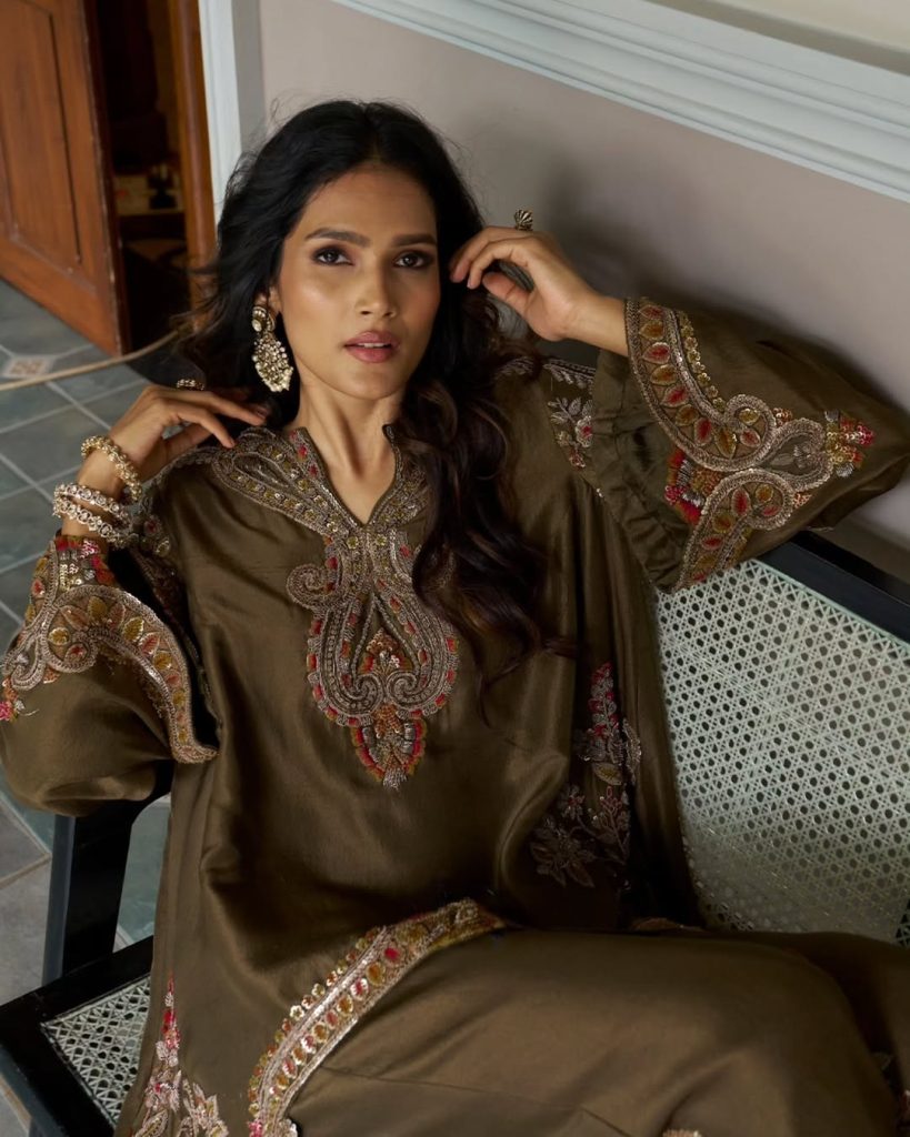 Bride in olive embroidered outfit wearing polki chandelier earrings and pearl accents. 