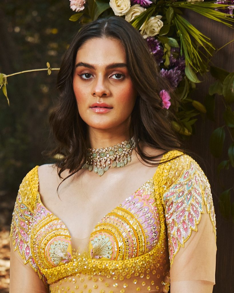 Bride in yellow lehenga wearing delicate diamond choker with soft green accents. 