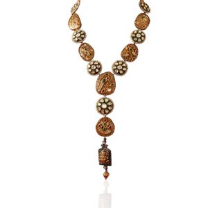 Long gold polki haar necklace with intricate motifs by Jagdish Jewellers on a dark brown mannequin.