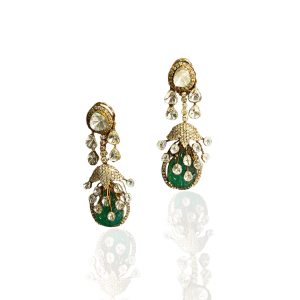 Long gold polki and emerald drop earrings by Laxmi Ganesh Jewellers against a warm brown backdrop.
