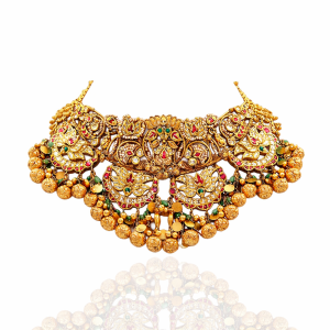 Antique temple inspired gold necklace with intricate gold bead drops displayed on red background