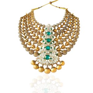 Statement gold necklace by SS Jewellers featuring layered gold motifs, emerald centre stones and textured gold bead drops on white background