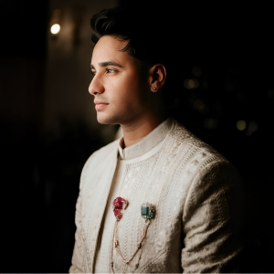 Abhishek Sharma wearing layered emerald necklaces with a traditional ivory outfit featuring jewellery by Khurana Jewellery House.