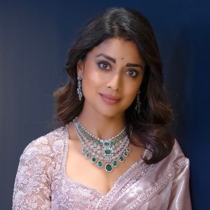 Shriya Saran wearing layered emerald and diamond necklace set by Manubhai Jewellers with a blush saree.