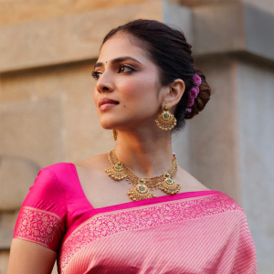 Malavika Mohanan wearing traditional gold necklace and earrings by The House of MBJ with a pink saree.