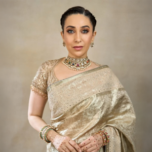 Karisma Kapoor wearing navratna gemstone choker necklace by Khurana Jewellery House with a gold saree.
