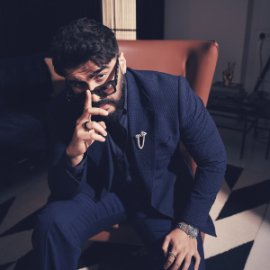 Arjun Kapoor wearing a navy suit with a diamond brooch and rings featuring jewellery by Mahesh Notandass.