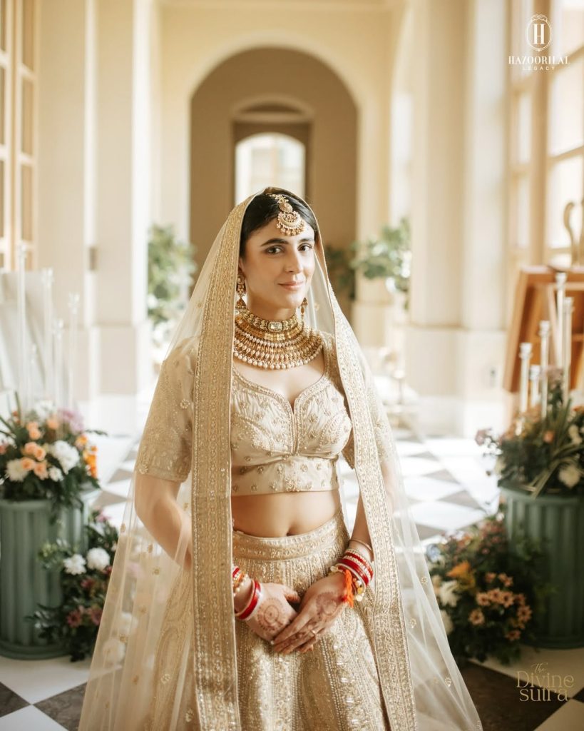 Bride in ivory lehenga wearing gold choker layered with polki detailing and pearl drops