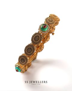 Gold kada with emerald accents in refined finish by SS Jewellers