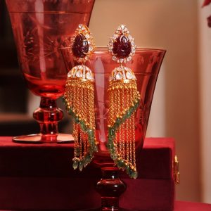 Gold tassel jhumka earrings with green beads by Sumeet Jewellers