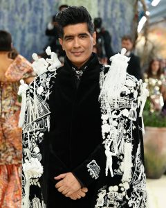 Manish Malhotra wearing statement brooch jewellery with embroidered cape at Met Gala 2026