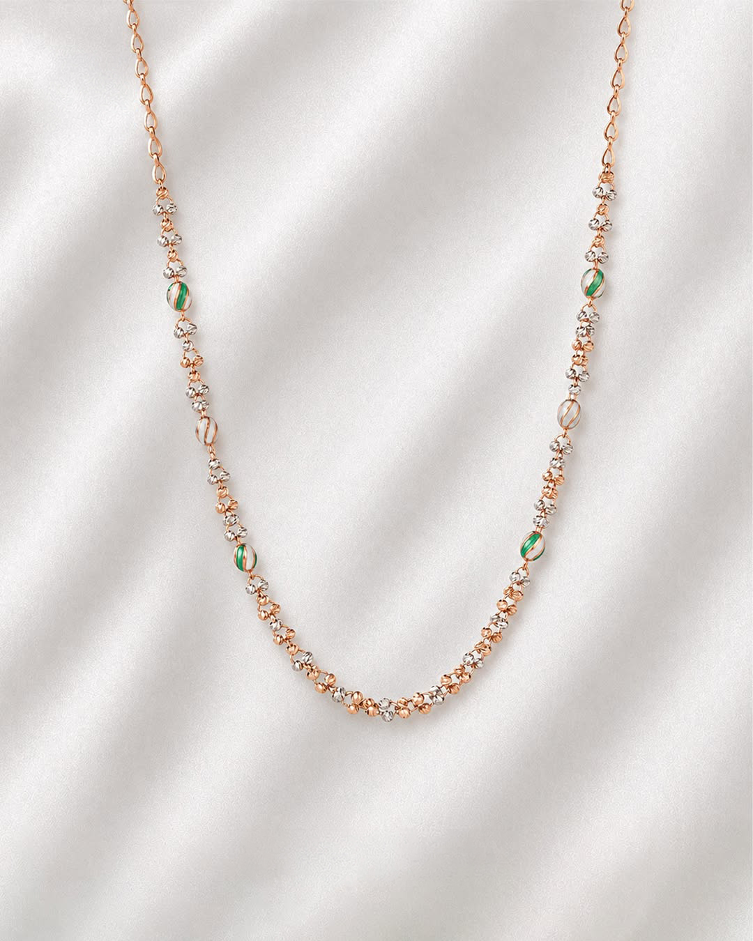 18KT rose gold necklace featuring textured beads and soft green accent elements by Manubhai Jewels