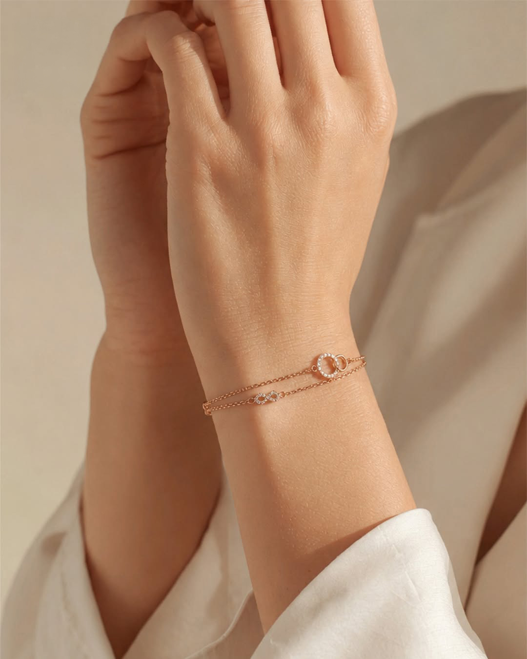 18KT rose gold double-chain bracelet with diamond-studded infinity motif by Manubhai Jewels
