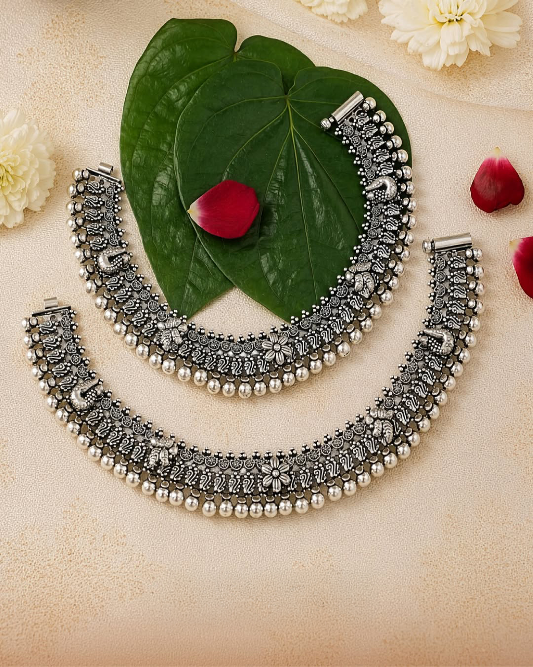 Oxidised silver payal with peacock motifs, floral detailing, and handcrafted beadwork by Navrattan Jewellers.