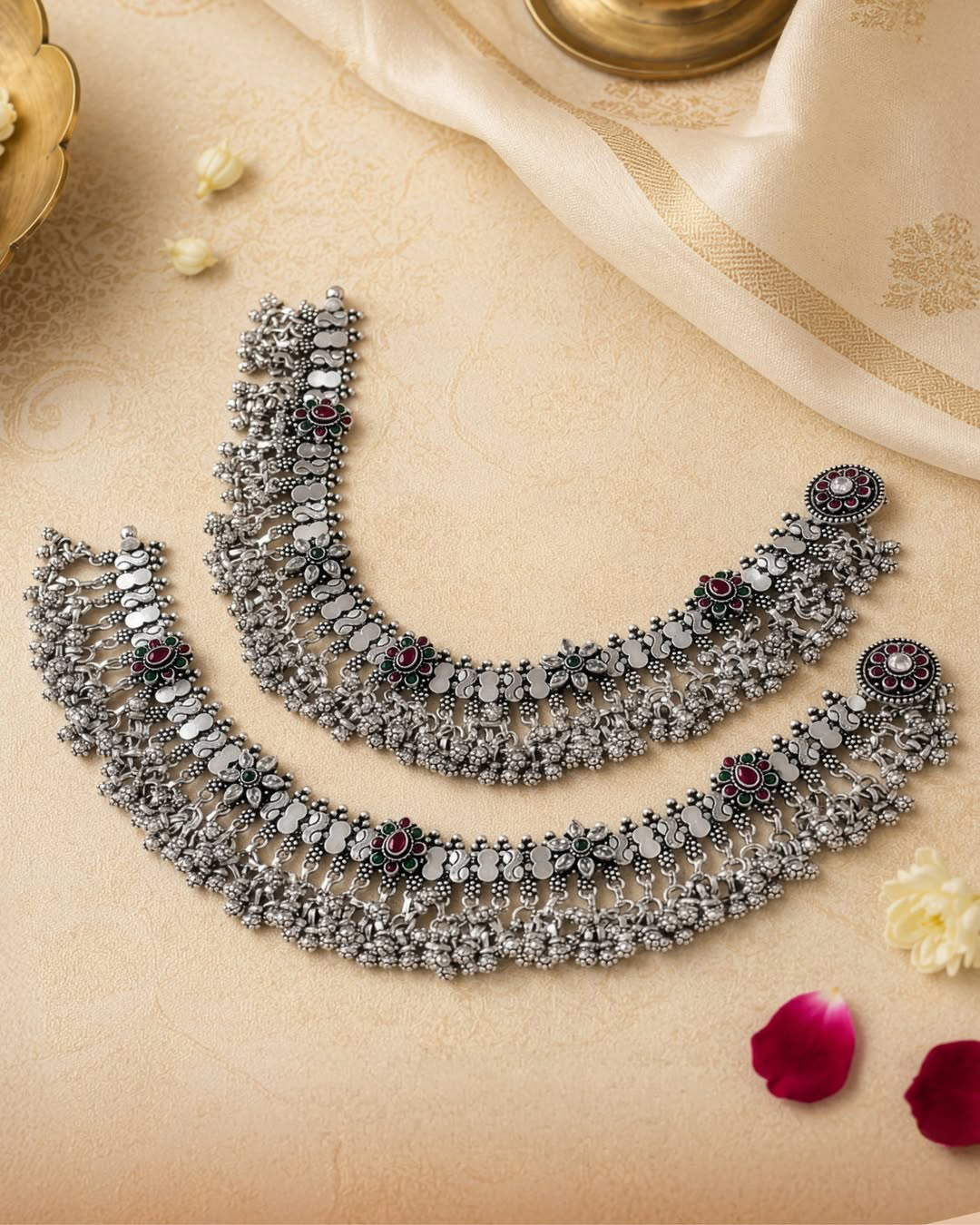 Statement silver payal adorned with floral motifs, gemstone-inspired accents, and cascading ghungroo detailing.