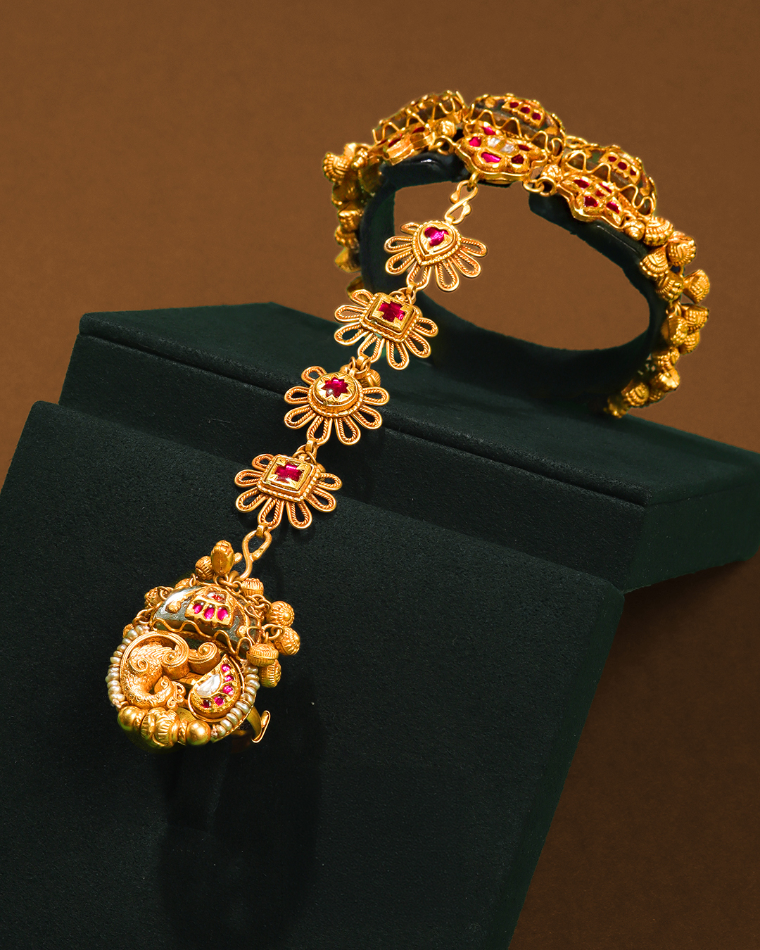 Heritage-inspired bridal ring bracelet by Chheda Jewellers with ruby accents, gold craftsmanship, and traditional detailing