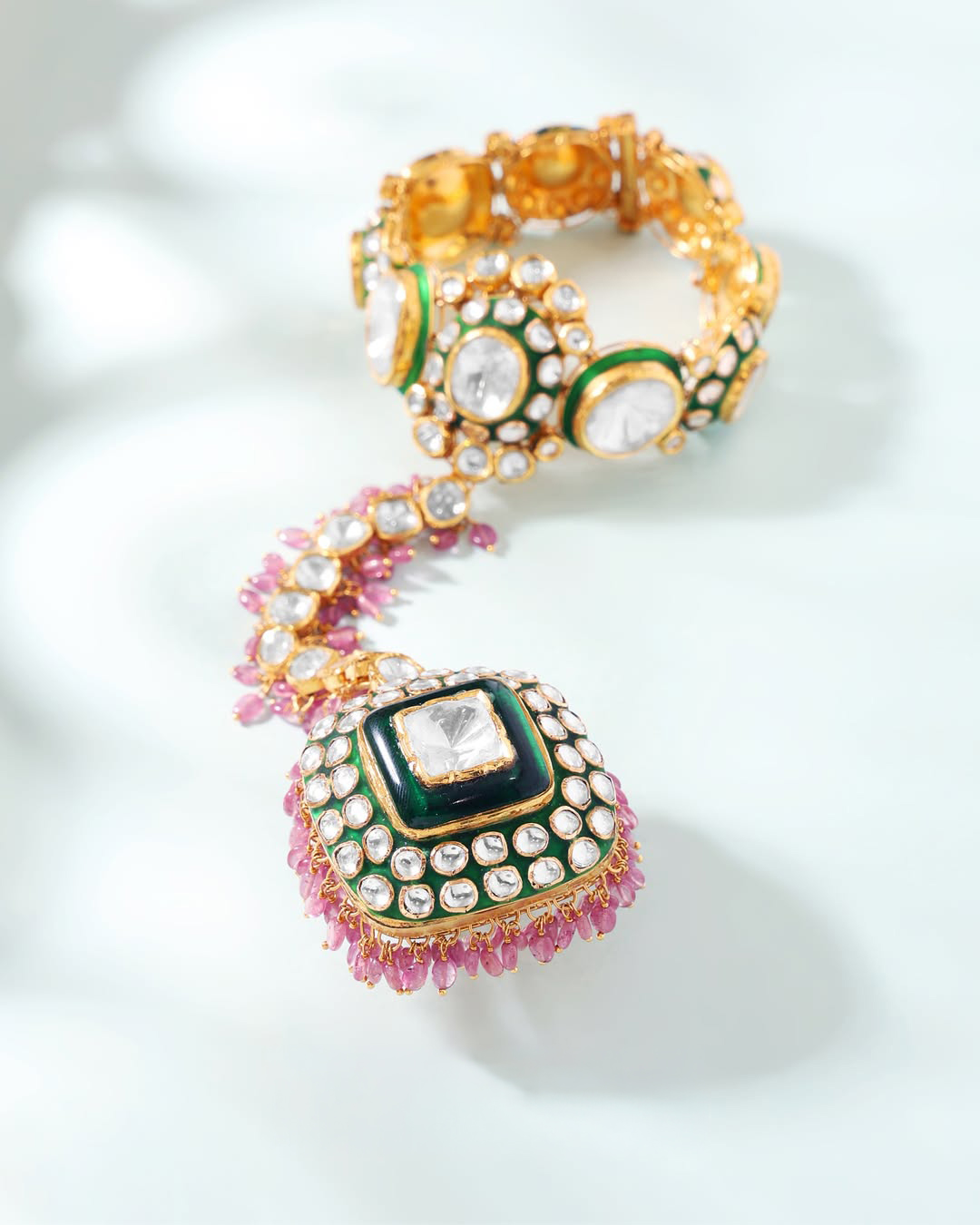 Bridal ring bracelet by SS Jewellers featuring green enamel detailing, uncut stones, pink gemstone accents, and traditional Indian craftsmanship