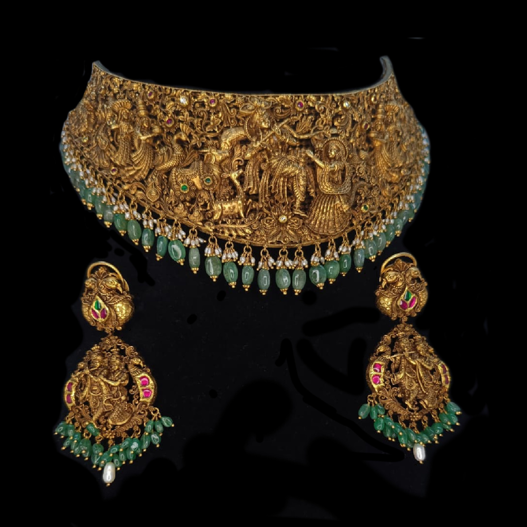 Sumeet Jewellers Krishna Leela sculpted gold bridal necklace and earrings with emerald green bead detailing