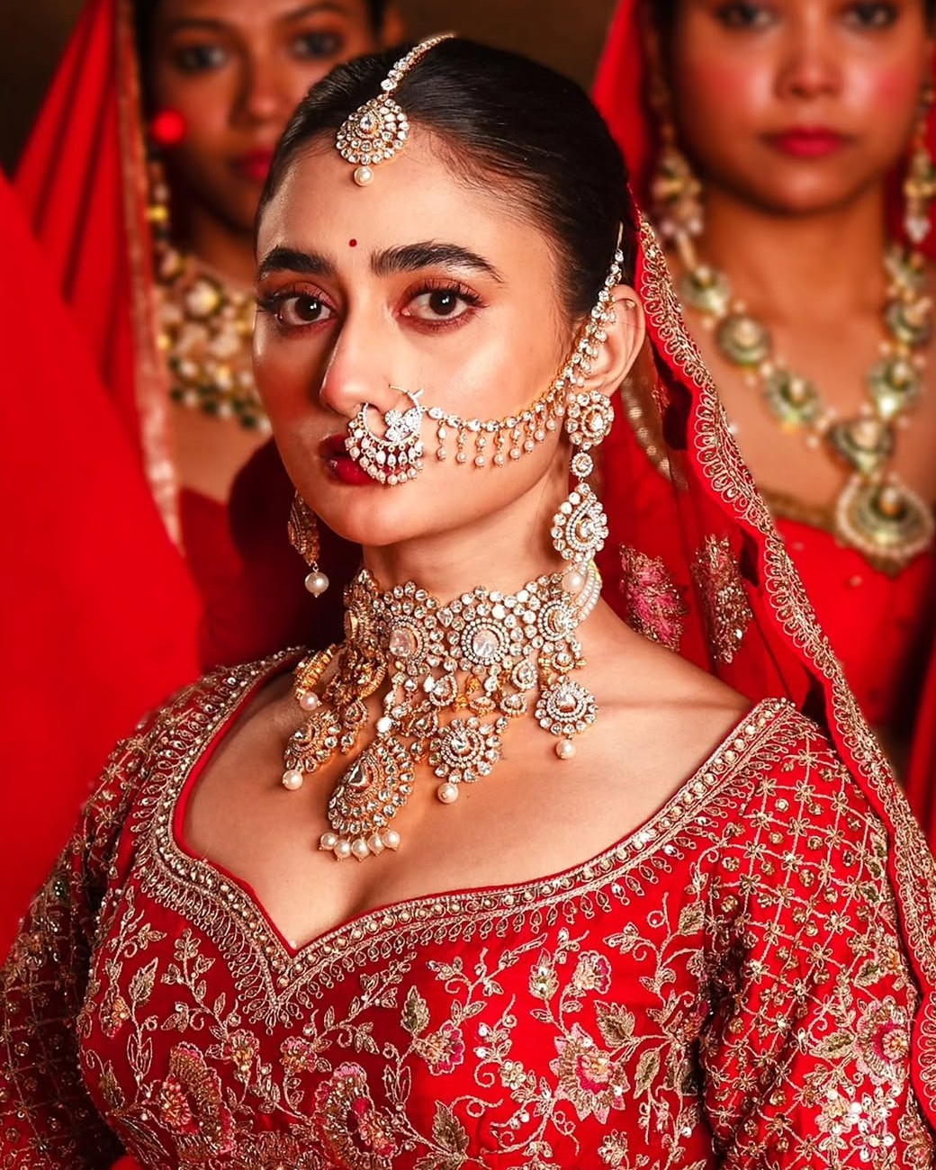 Bride in diamond bridal jewellery by Sawansukha Jewellers featuring an elaborate diamond choker, matching earrings and bridal nose ring.