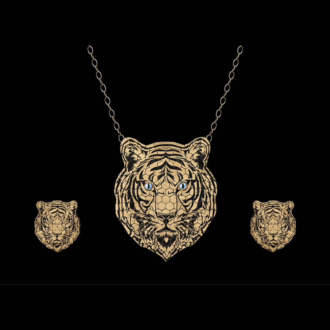 Kalamandir Jewellers Vyāghra couture jewellery set featuring a detailed tiger-head pendant and matching earrings in gold with gemstone accents.