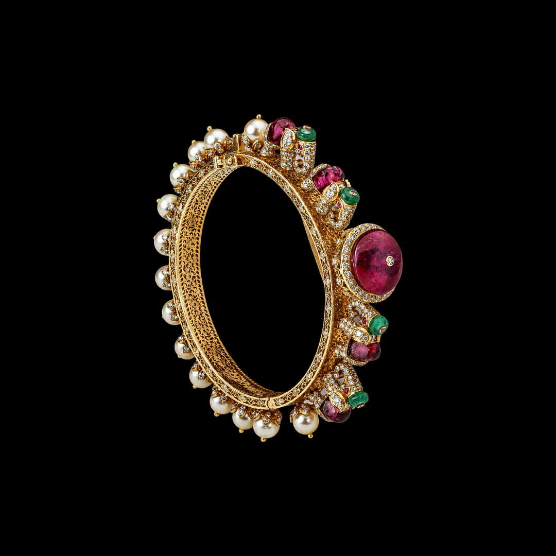 Kalavarni Jewels Royale Gaja bangle featuring intricate gold craftsmanship, pearls and precious coloured gemstones inspired by Indian royal heritage. 