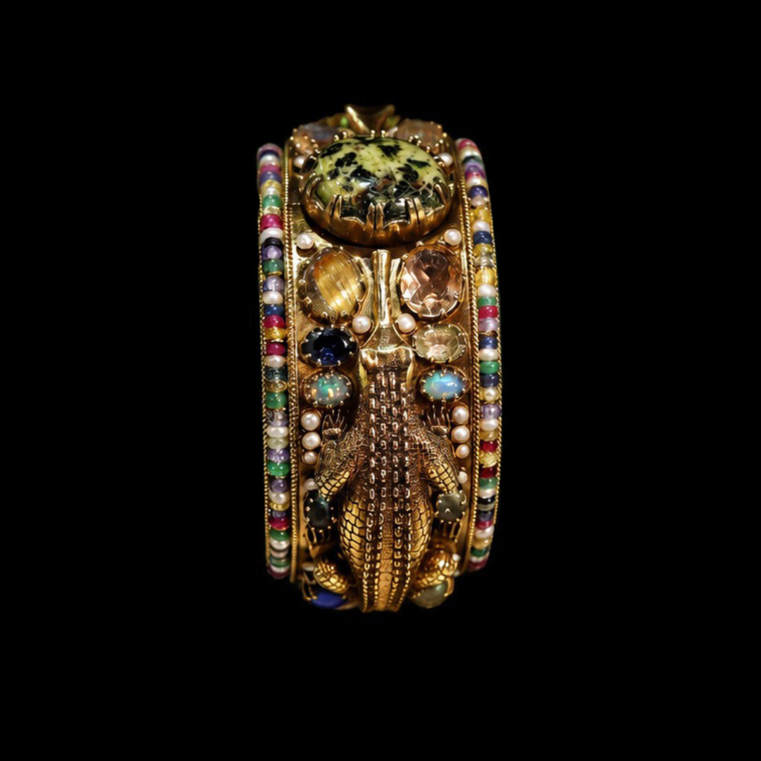 SS Jewellers Makarā studded gold bangle with multicoloured gemstones, intricate gold detailing and a sacred water-inspired design.